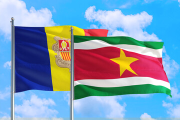 Suriname and Andorra national flag waving in the windy deep blue sky. Diplomacy and international relations concept.