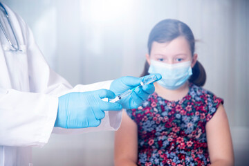 Vaccination concept. Male doctor vaccinating cute little girl in clinic.