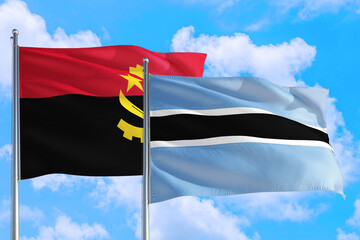Botswana and Angola national flag waving in the windy deep blue sky. Diplomacy and international relations concept.