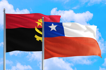 Chile and Angola national flag waving in the windy deep blue sky. Diplomacy and international relations concept.