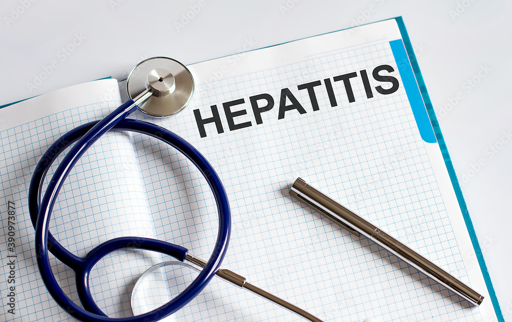 Poster paper with text hepatitis on a table with stethoscope
