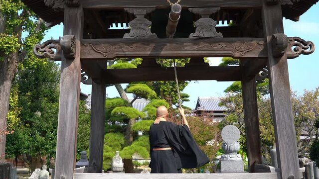 お坊さんが鐘を鳴らしているイメージ
