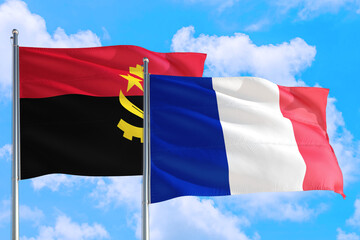 France and Angola national flag waving in the windy deep blue sky. Diplomacy and international relations concept.