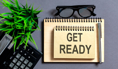 Top view ,pen,glasses ,calculator and notebook written Get ready on grey background.