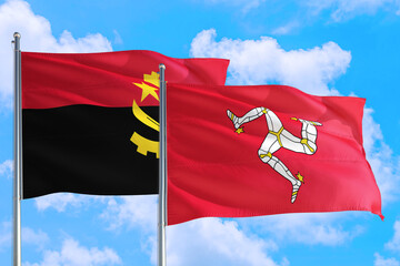 Isle Of Man and Angola national flag waving in the windy deep blue sky. Diplomacy and international...