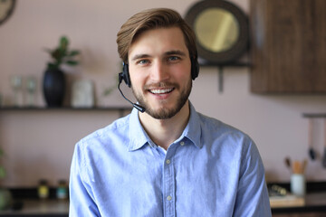 Male customer support operator with headset and smiling.