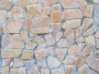 A wall with disorderly stonework. Background texture. Full screen