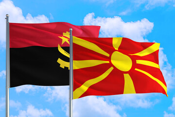Macedonia and Angola national flag waving in the windy deep blue sky. Diplomacy and international...