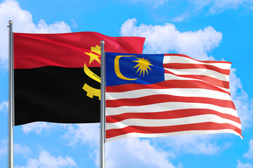Malaysia and Angola national flag waving in the windy deep blue sky. Diplomacy and international relations concept.