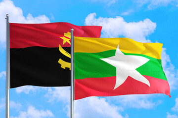Myanmar and Angola national flag waving in the windy deep blue sky. Diplomacy and international...
