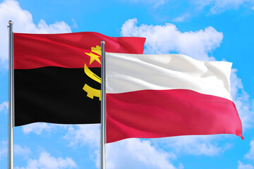 Poland and Angola national flag waving in the windy deep blue sky. Diplomacy and international relations concept.