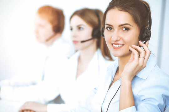 Call center. Focus on beautiful business woman in headset