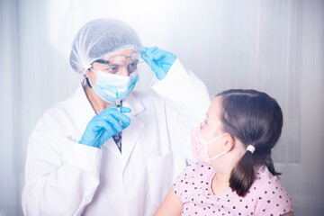 Vaccination concept. Female doctor vaccinating cute little girl in clinic.