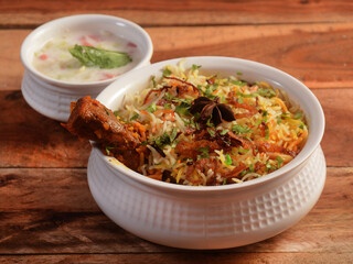 Traditional Hyderabadi Chicken dum Biryani made of Basmati rice cooked with masala spices, served with Onion raita, selective focus