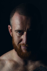 Studio session with one muscular man in low-key light conditions