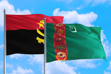 Turkmenistan and Angola national flag waving in the windy deep blue sky. Diplomacy and...