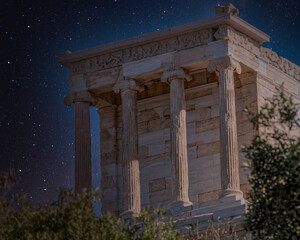 Athena Nike ancient Greek temple on Acropolis hill night view under starry sky, Athens Greece