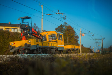 Yellow work train on a slight curve, rushing to fix the train tracks.