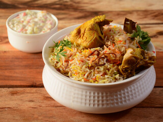 Traditional Hyderabadi Chicken dum Biryani made of Basmati rice cooked with masala spices, served with Onion raita, selective focus