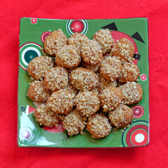 melomacarona, traditional Greek Christmas gourmet cookies with honey syrup and nuts, served on red fabric background
