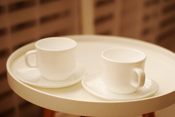 Two white cups for tea drinking on a white tray