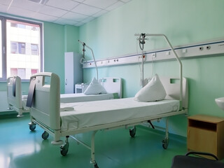 Two hospital beds on wheels in a hospital bed on windows backgraund