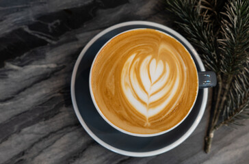 coffee art latte in cup on the marble table in cafe