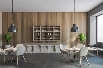 Grey cafe with chairs and wooden table with pendant lamps, wooden wall and grey floor