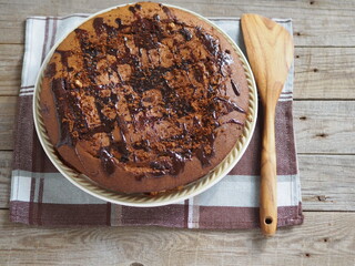 Closeup of a cupcake sprinkled with chocolate icing on an ancient wooden background. Homemade healthy food.