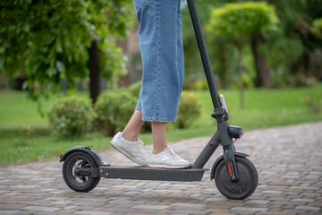 Obraz premium Close up picture of woman legs standing on a scooter
