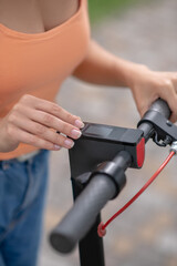 Close up picture of womans hand pressing buttins on a handlebar