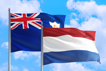 Netherlands and Anguilla national flag waving in the windy deep blue sky. Diplomacy and international relations concept.