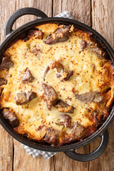 Tave kosi soured milk casserole of lamb and rice baked with a mixture of yogurt and eggs closeup in the pan on the table. Vertical top view from above - obrazy, fototapety, plakaty