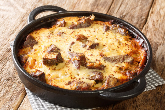 Albanian Baked Lamb and Rice with Yogurt Tave Kosi close-up in a pan on the table. horizontal