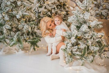 Obraz na płótnie Canvas Winter holiday concept. Inspiration and fairy time. Mom and little girl near Christmas tree at holydays. Pretty nice cozy holiday days, magical Christmas time