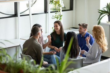 Business training. Group of positive inspired professional employees managers teammates sitting in circle at office space providing meeting training briefing, creating ideas, talking, sharing opinions