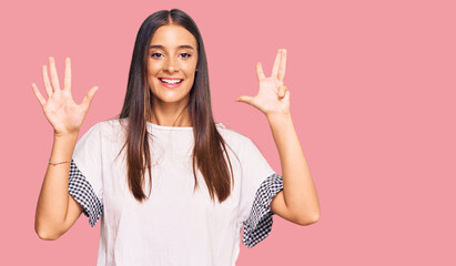 Young hispanic woman wearing casual clothes showing and pointing up with fingers number nine while...