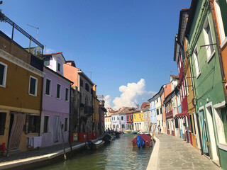 Burano island canal and colorful houses with boats in Venice Italy