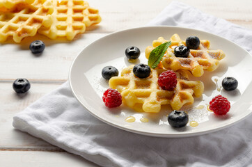 Waffles with fresh blueberries for breakfast on white table