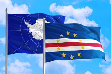 Cape Verde and Antarctica national flag waving in the windy deep blue sky. Diplomacy and international relations concept.