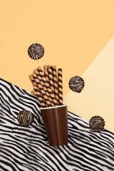 Chocolate cookies mix, waffle rolls and plastic cup. Zebra print. Sweets sugar lover concept. Minimal art. Holidays party time, winter christmas celebration season