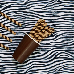 Chocolate cookies waffle rolls in cup and zebra print background. Sweets sugar lover concept. Minimal art. Holidays party time, winter christmas celebration season