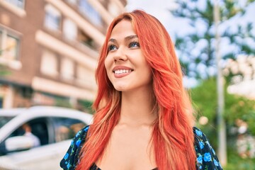 Young redhead girl smiling happy walking at street of city.