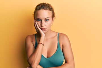 Obraz premium Beautiful caucasian woman wearing sleeveless shirt over yellow background thinking looking tired and bored with depression problems with crossed arms.