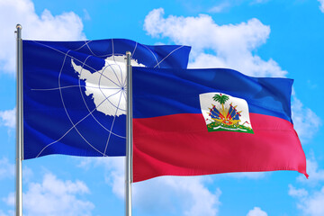 Haiti and Antarctica national flag waving in the windy deep blue sky. Diplomacy and international relations concept.