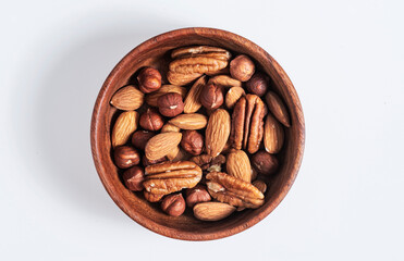 Mixed nuts in wooden bowl on white background.
protein source. Isolated.
