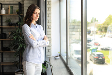 Fototapeta premium Cheerful woman student professional standing at home in office looking at camera.