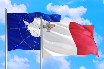 Malta and Antarctica national flag waving in the windy deep blue sky. Diplomacy and international...