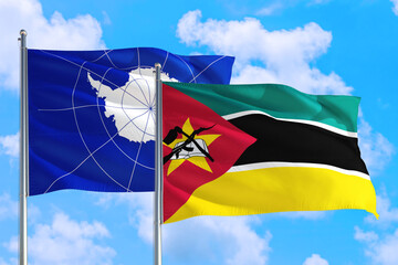 Mozambique and Antarctica national flag waving in the windy deep blue sky. Diplomacy and...