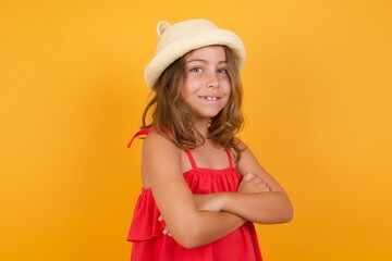 young Caucasian girl standing against yellow background, looking, observing, keeping an eye on an object in front, or watching out for something.